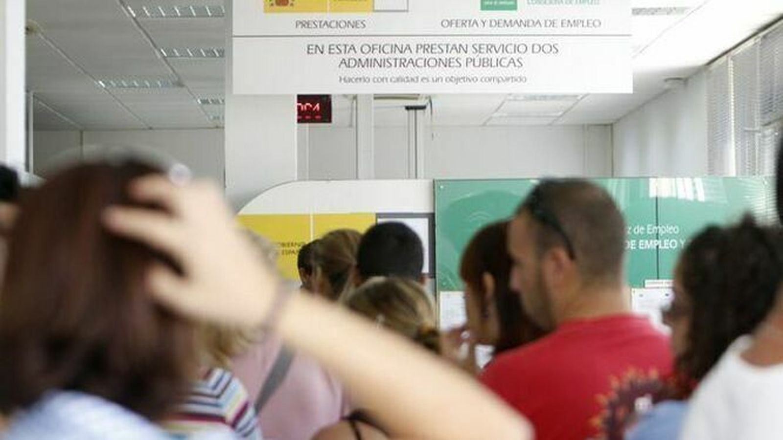 Varias personas en el interior de una oficina de empleo.