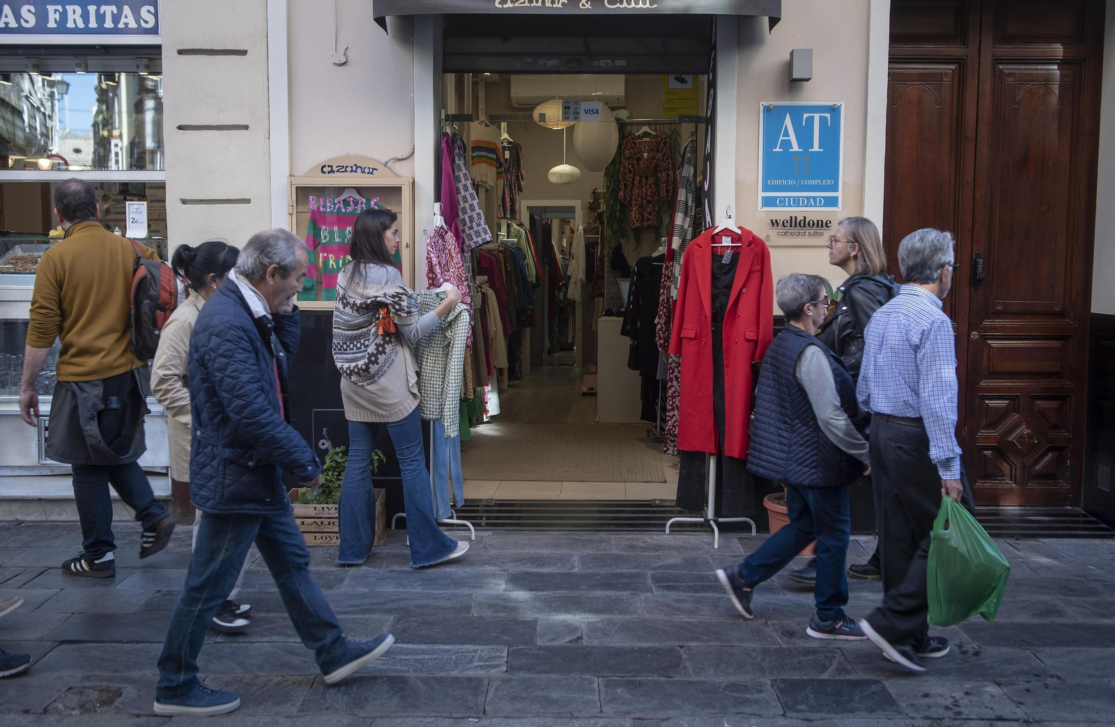 Un grupo de personas pasa junto a un apartamento turístico.