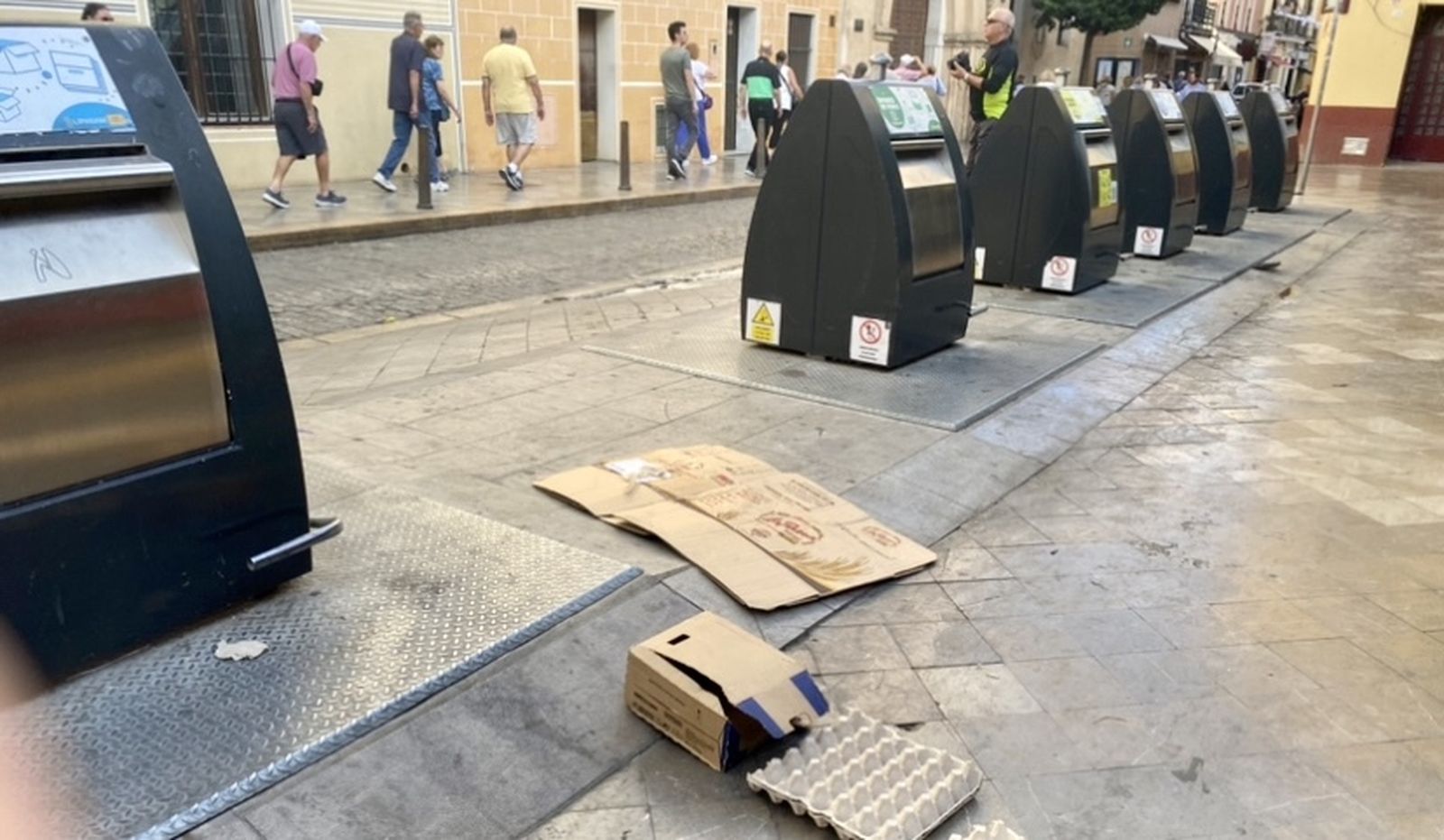 Turistas, contenedores y restos de basura.