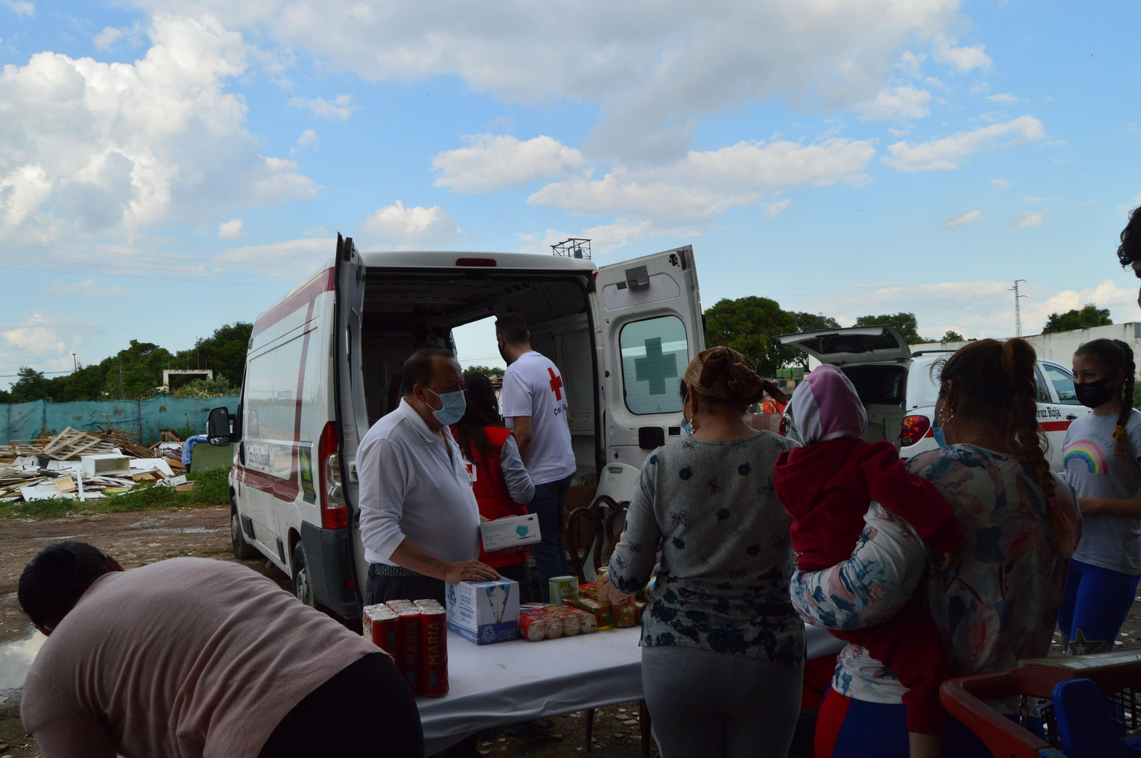 Los voluntarios de Cruz Roja reparten comida en un asentamiento.