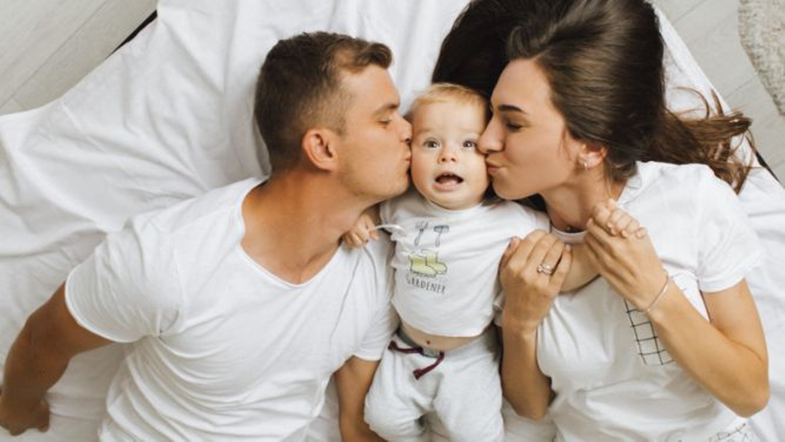 Pareja con bebé en la cama.
