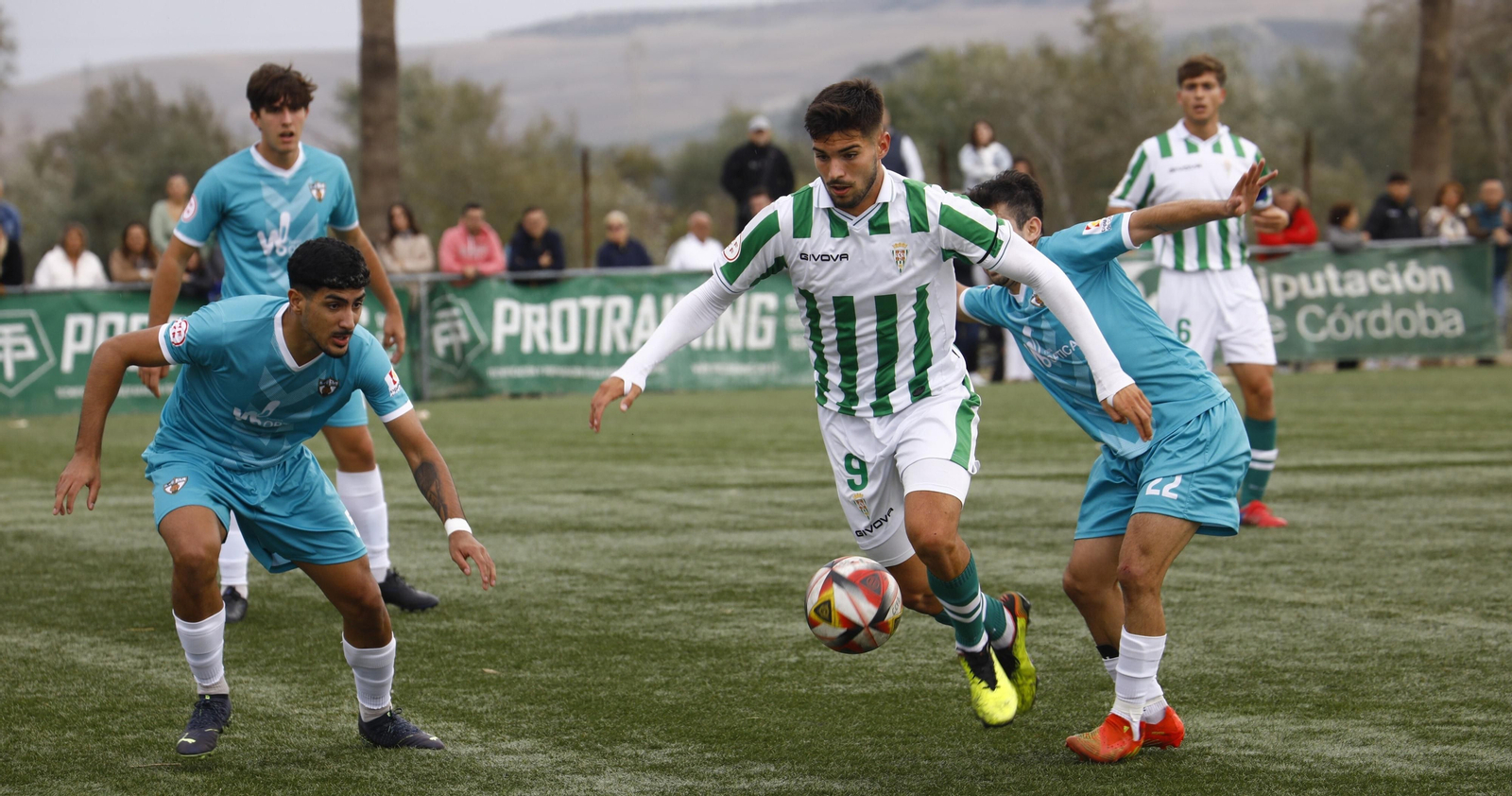 Óscar Jiménez, ariete del Córdoba B, rodeado por varios jugadores del Pozoblanco.