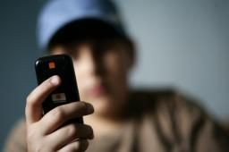 Un adolescente consulta un móvil