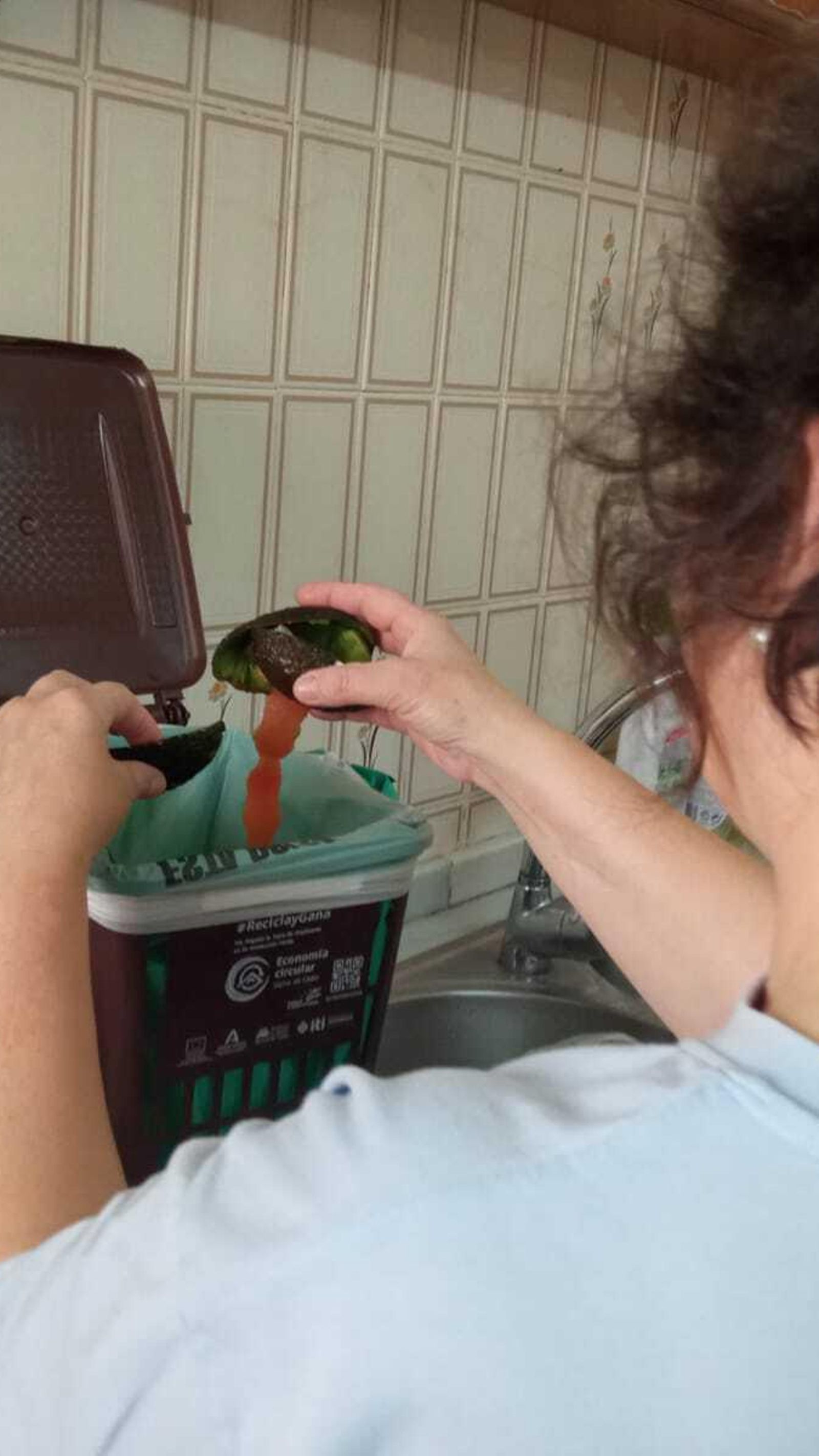 Una vecina mete en un contenedor materia orgánica