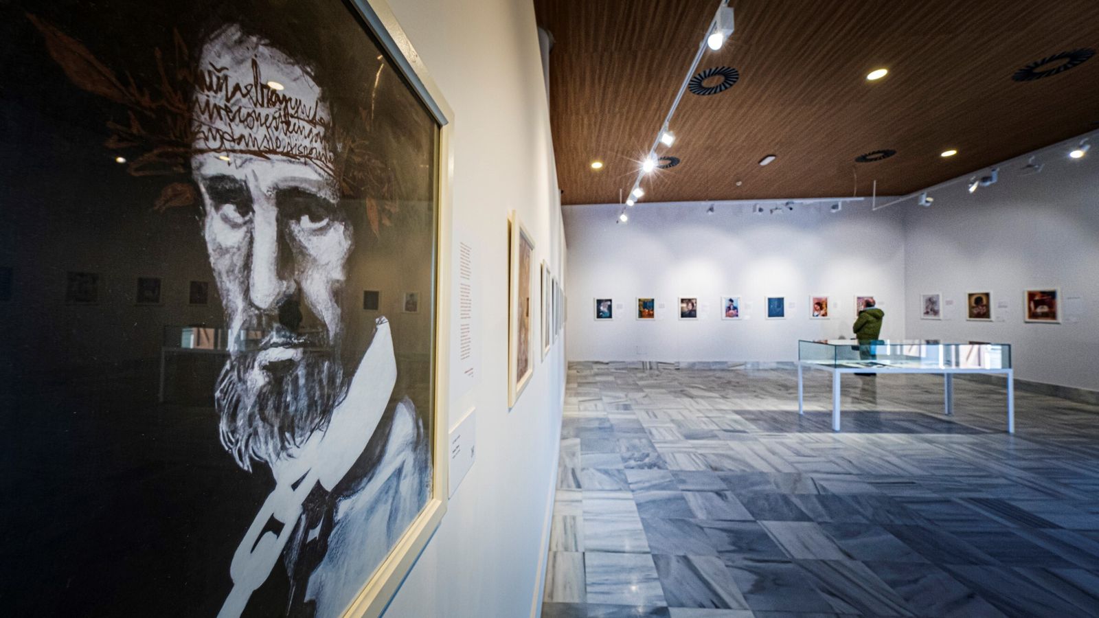 Una de las ilustraciones de la exposición en una imagen más amplia de la sala en la que se muestran las obras.