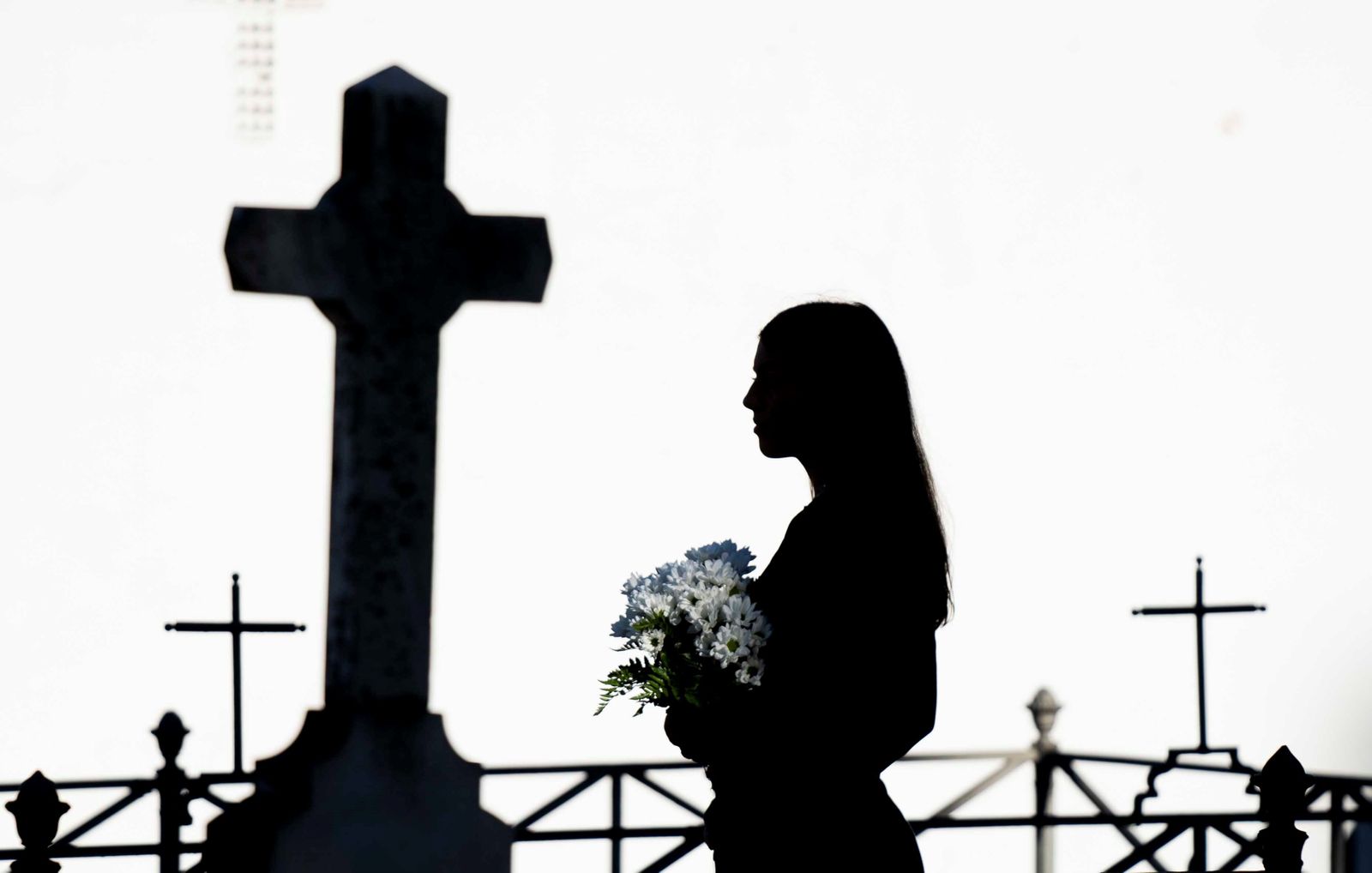 Una mujer pasea, con flores, por el cementerio de Monturque.