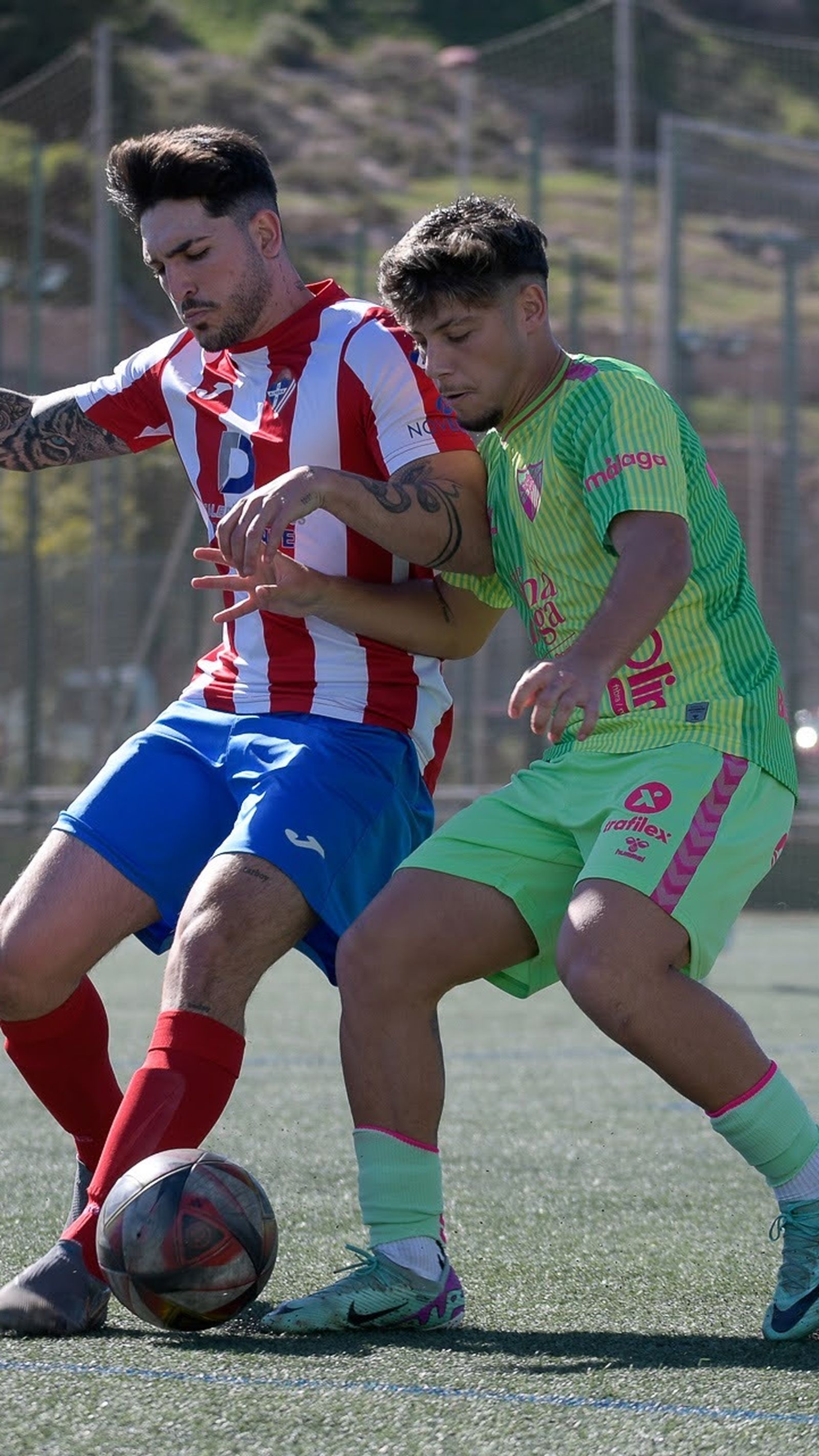 Dos jugadores se disputan un balón.