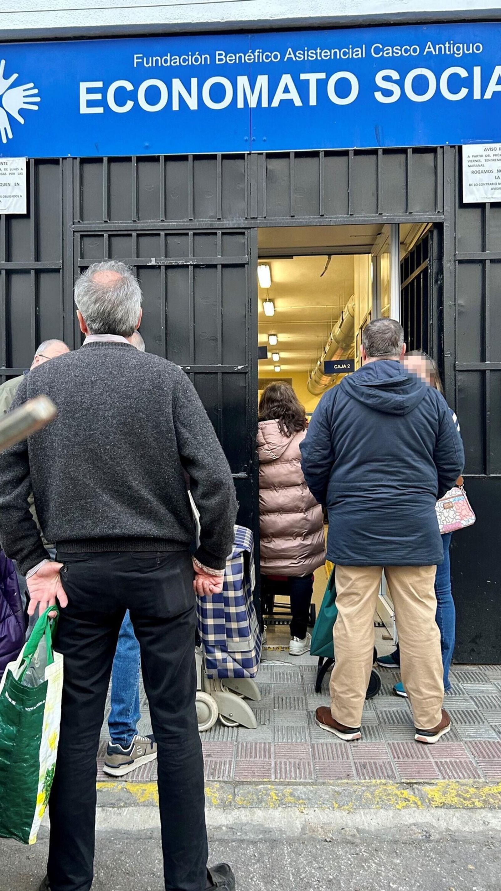 Varias personas aguardan su turno en la puerta del local de la calle Narciso Bonaplata.