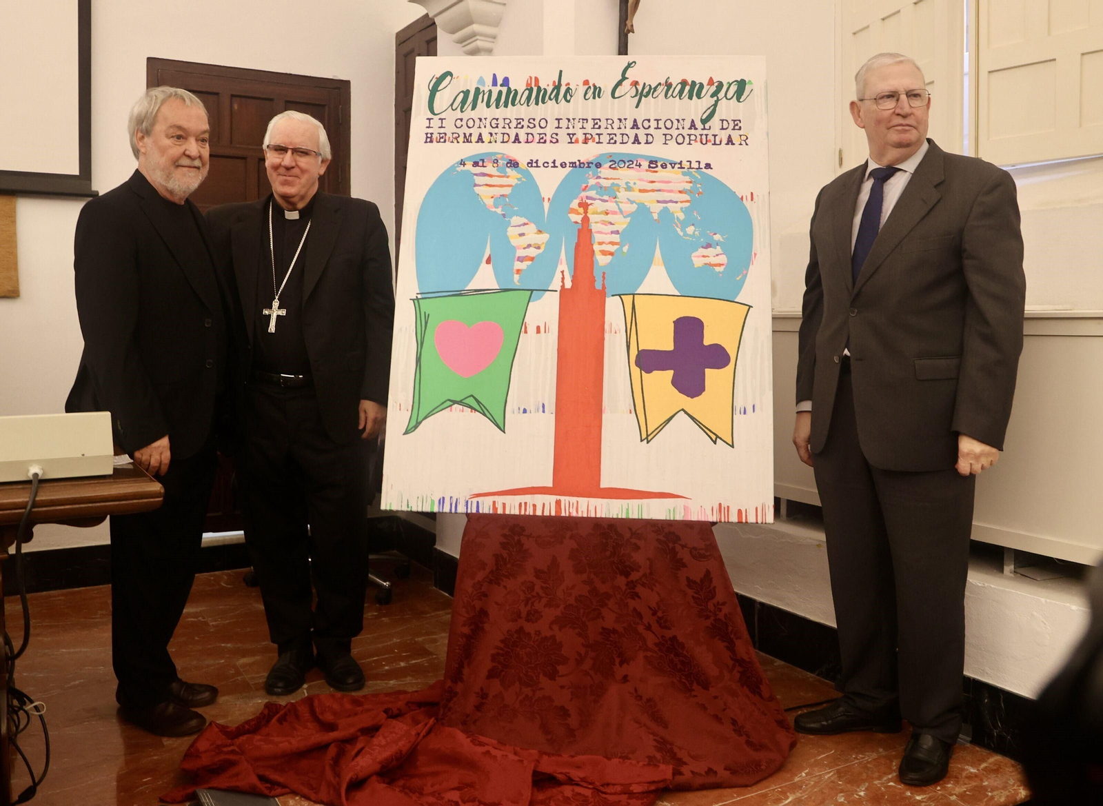 El pintor Manuel Cuervo, el arzobispo José Ángel Saiz y el presidente del Consejo de Cofradías, Francisco Vélez, junto al cartel del congreso.