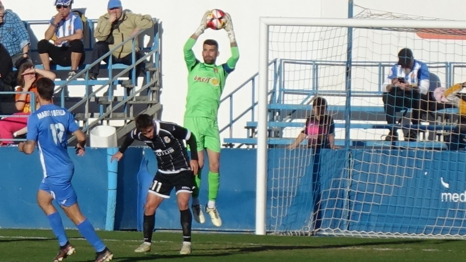 El meta local Iván Buigues atrapa el balón ante Fran Carbià