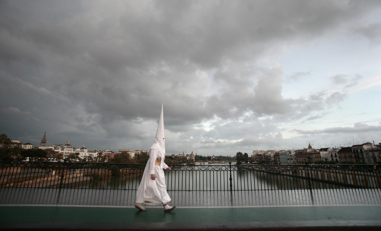 Un nazareno por el Puente de Triana.
