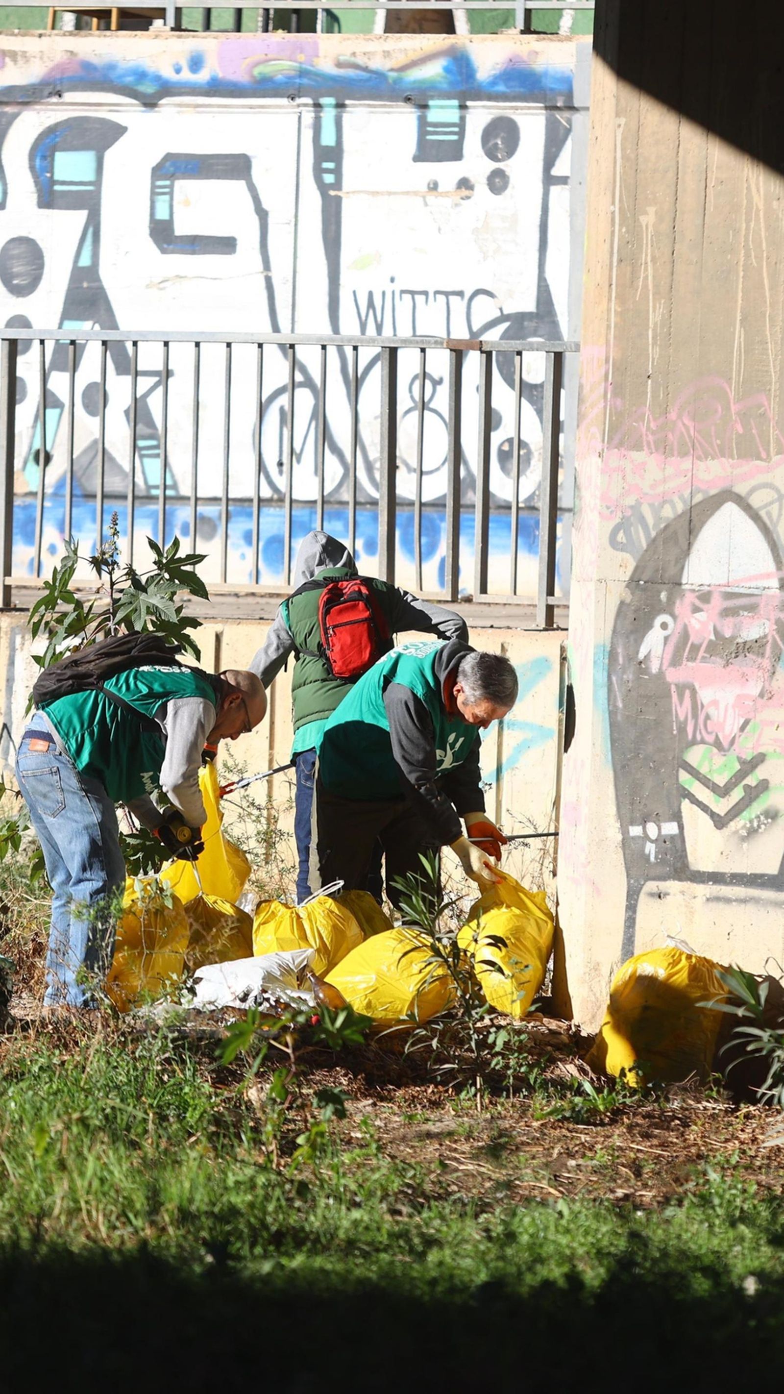 Voluntarios introducen en bolsas toda la basura recogida del cauce del río.