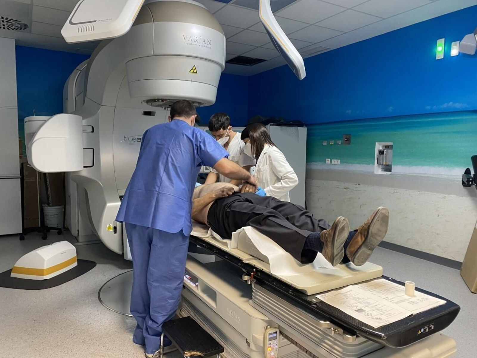 Sanitarios preparan a un paciente para recibir radioterapia.