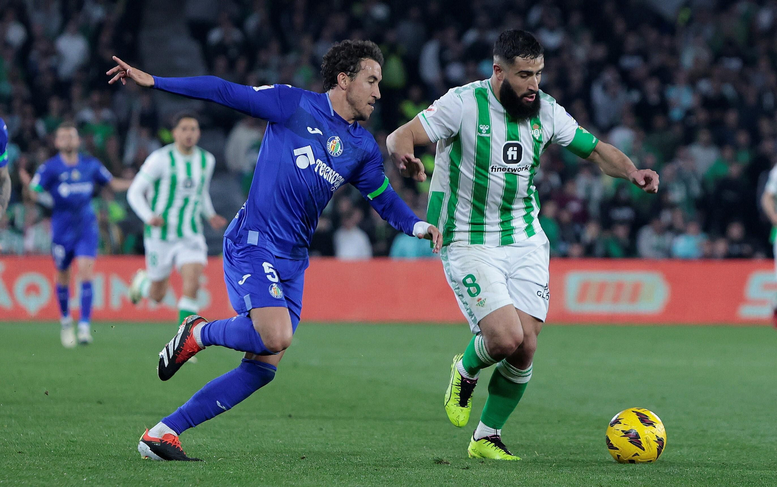 Fekir pugna con Luis Milla por el balón.