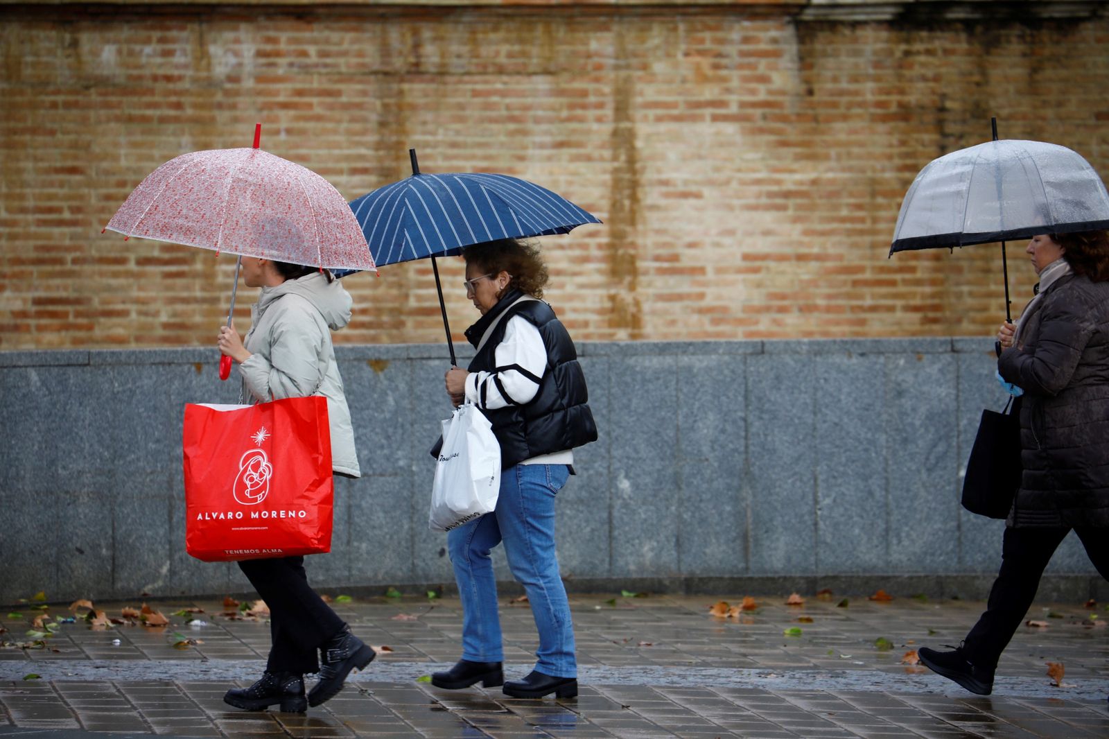 Varias personas se protegen con sus paraguas de la lluvia.