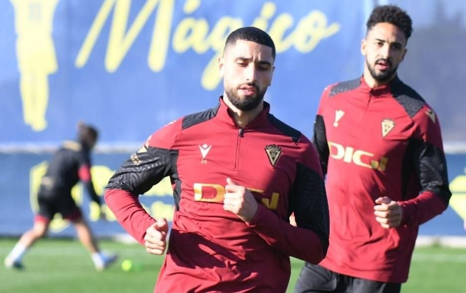 Aiham Ousou realiza carreras con Chris Ramos a su espalda en su primer entreno con el Cádiz.