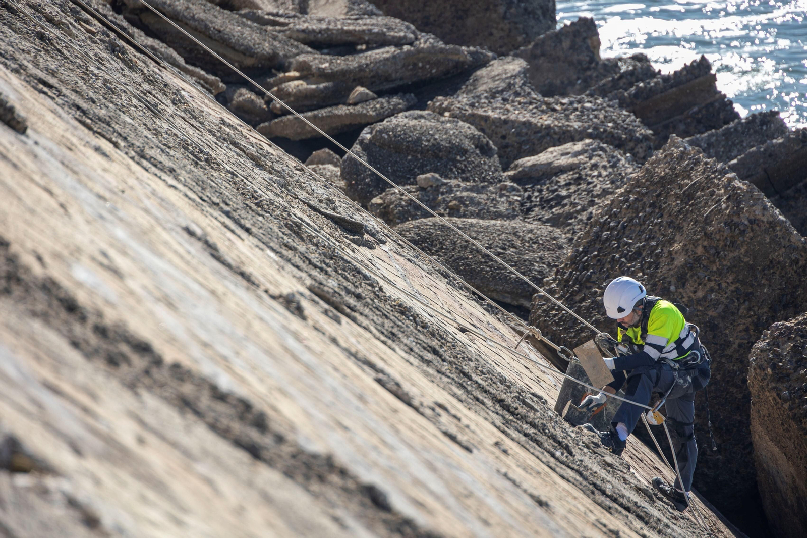 Operarios trabajan en la reparación en la muralla bajo el colegio del Campo del Sur.