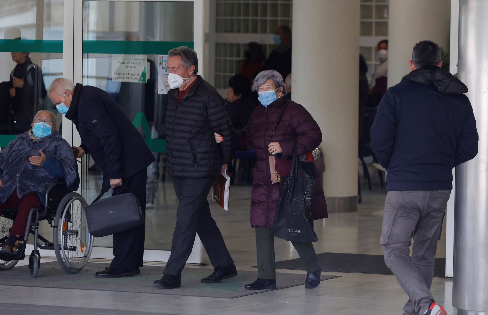 Varias personas con mascarilla a las puertas del Hospital Virgen del Rocío.