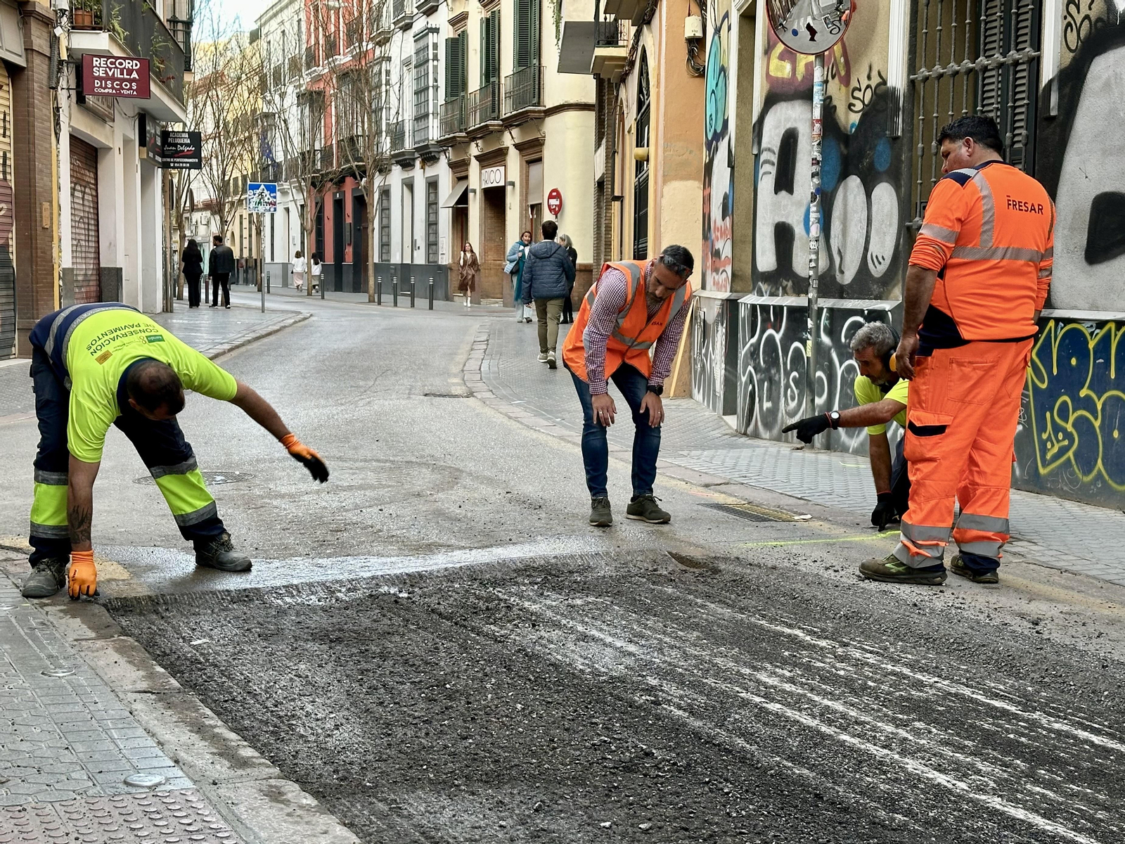 Varios operarios marcan la calzada en la calle Amor de Dios casi a la altura de su confluencia con San Miguel.