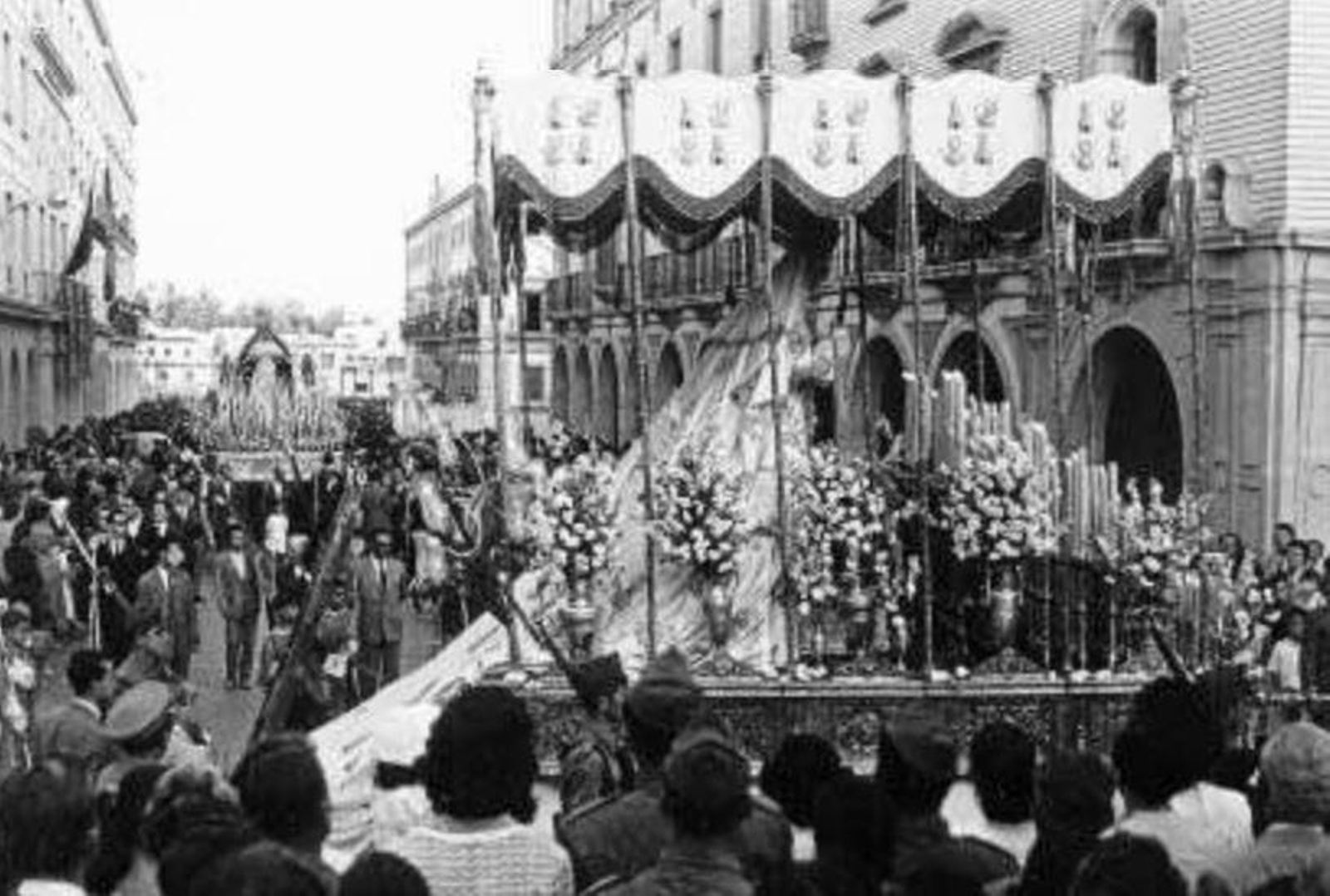 El palio de La Paz abandona la Gran Vía y, al fondo, la Virgen del Refugio.