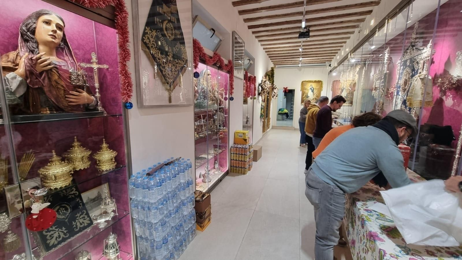 Cofrades del Perdón preparan lotes de comida para personas sin hogar en su casa de hermandad.