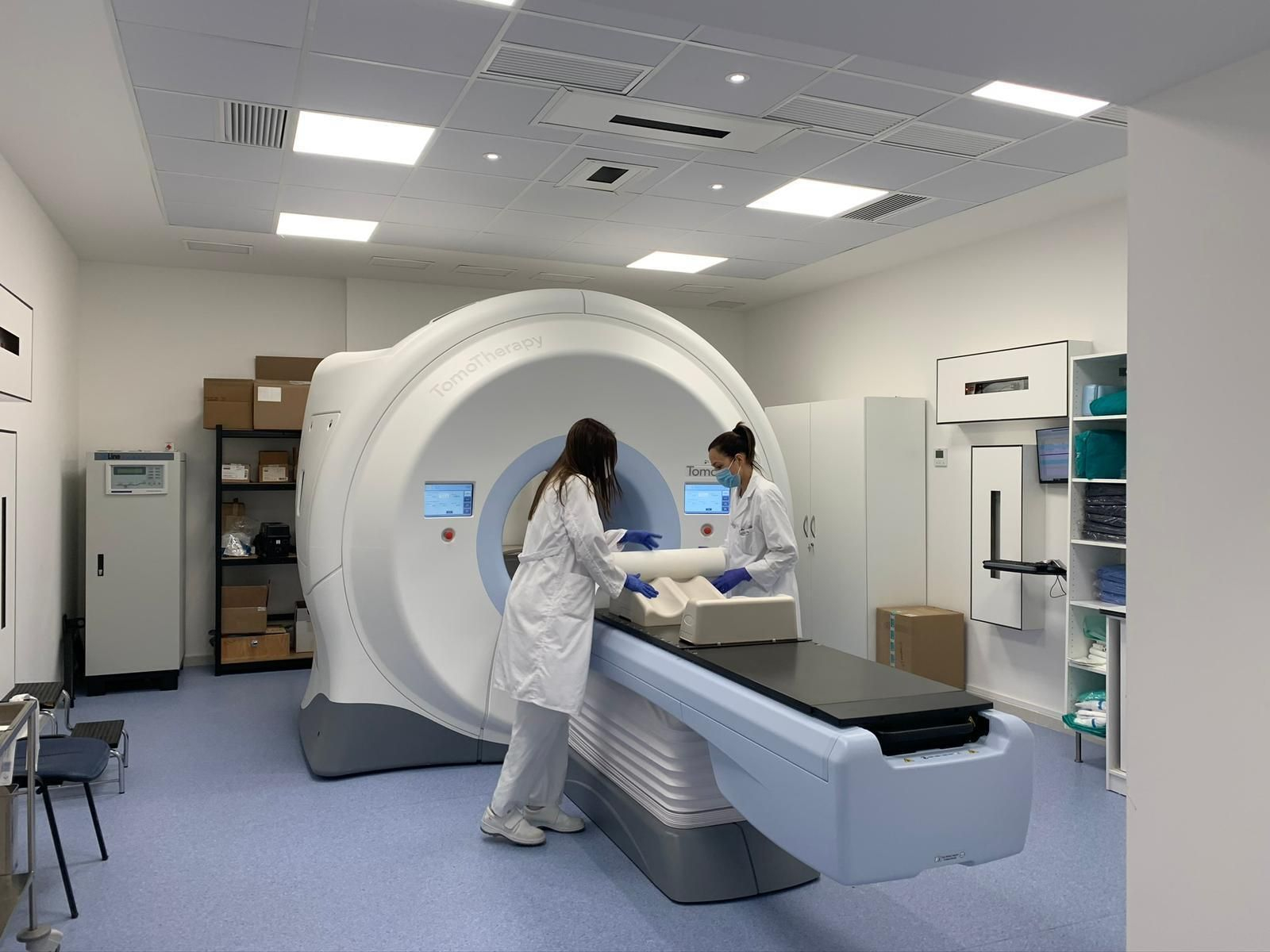 Dos sanitarias preparan un aparato para tratar a un paciente.