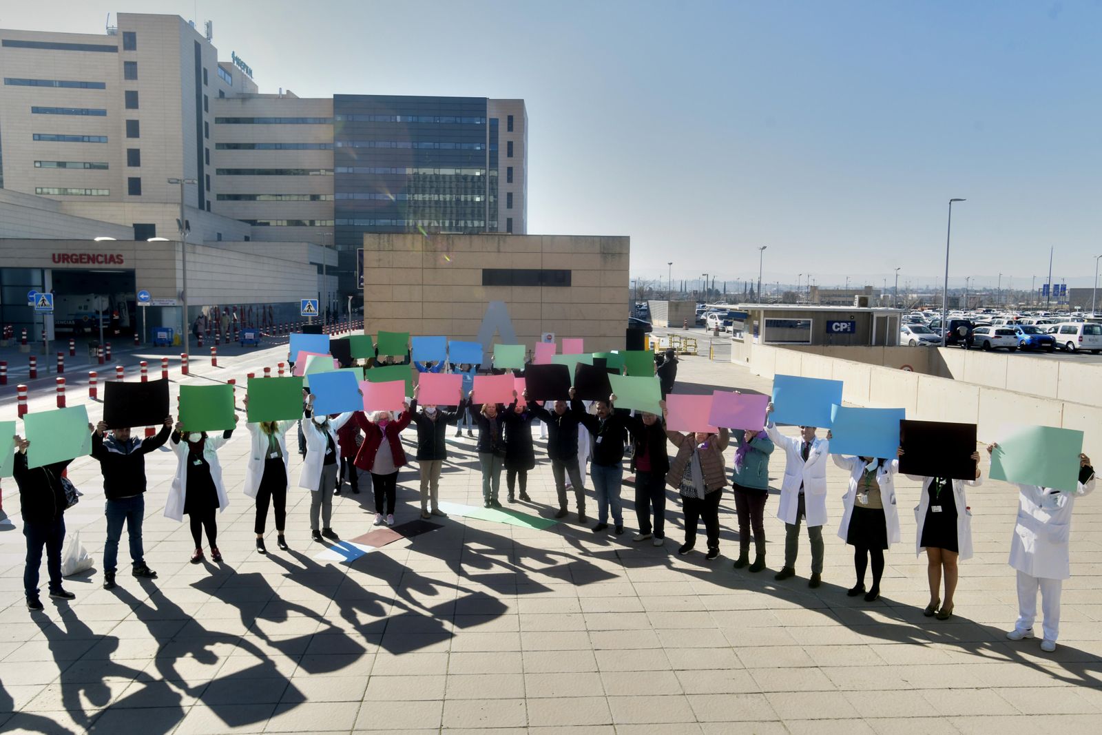 Sanitarios del Clínico San Cecilio dibujan un lazo con cartulinas multucolor en el Día Mundial contra el Cáncer