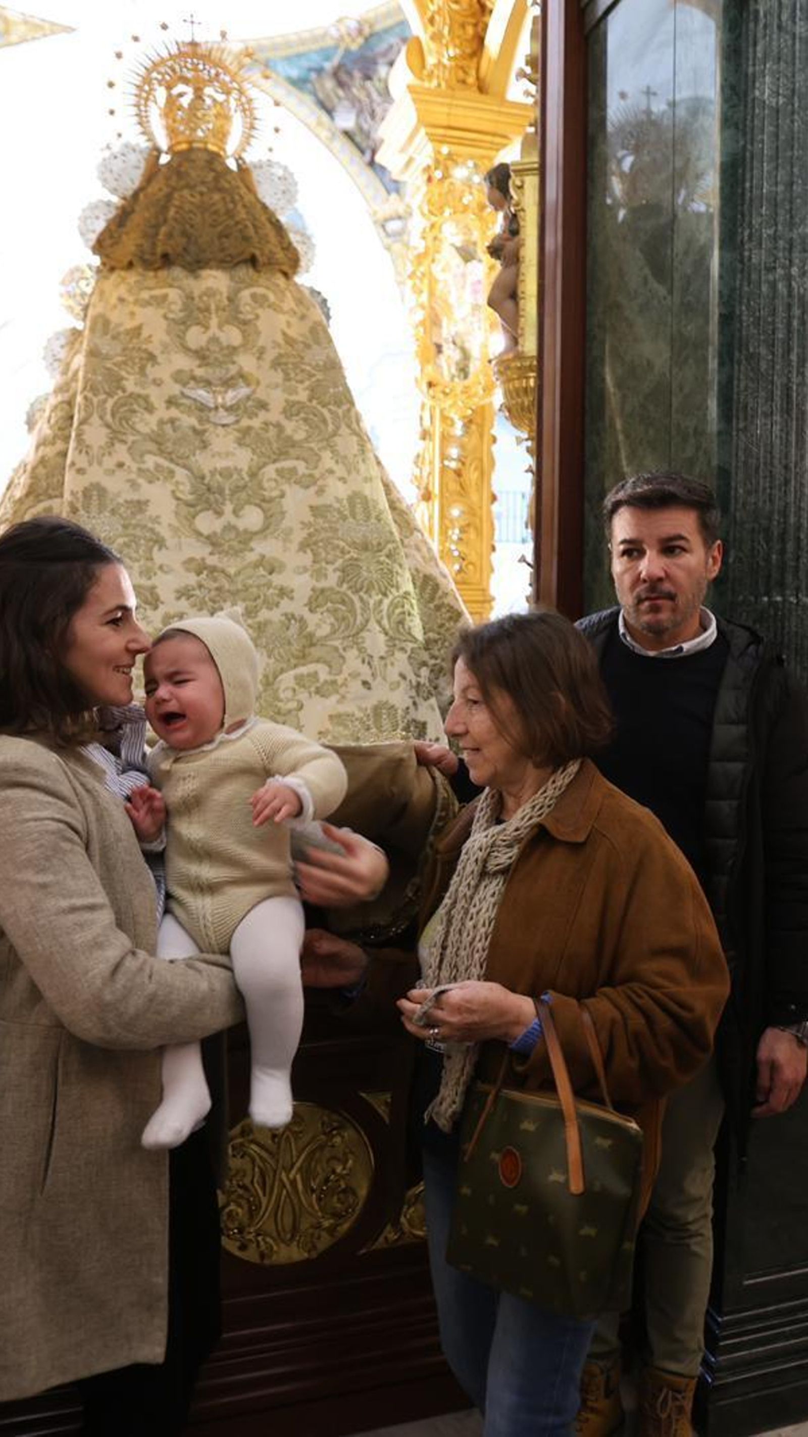 Pasan a un niño por debajo del manto de la Virgen.