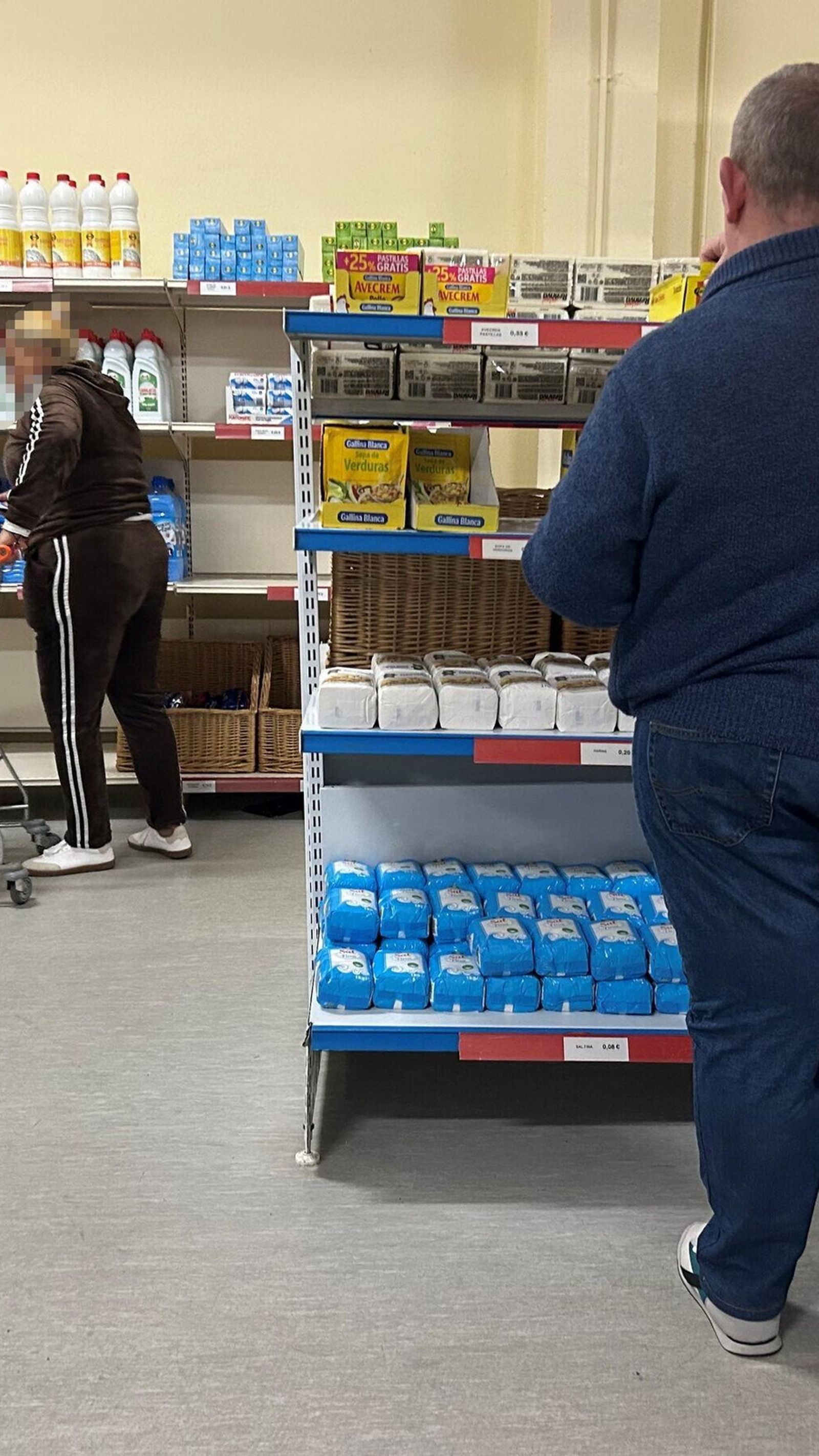 Dos personas hacen su compra en el interior del economato.