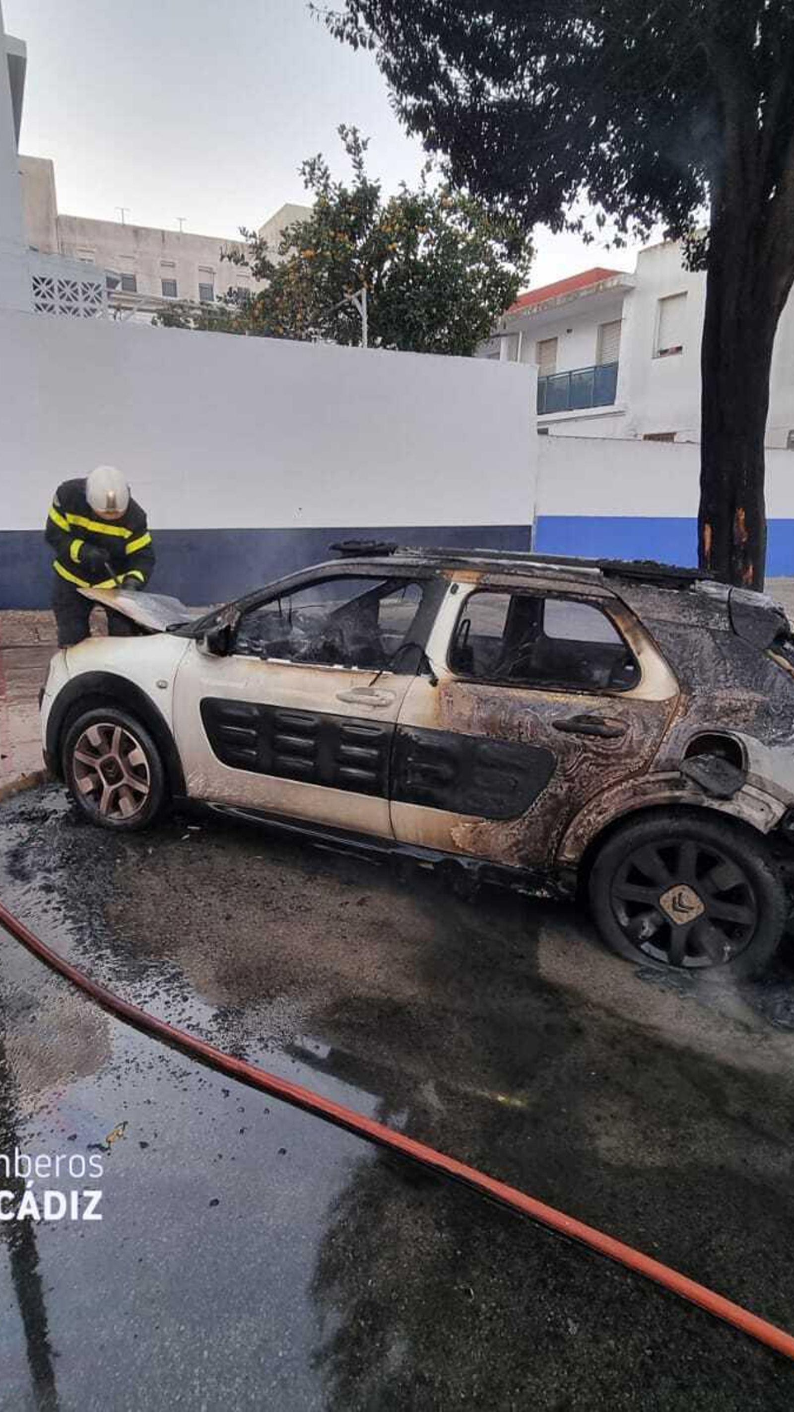 Bomberos sofocando el incendio del vehículo en San Fernando.