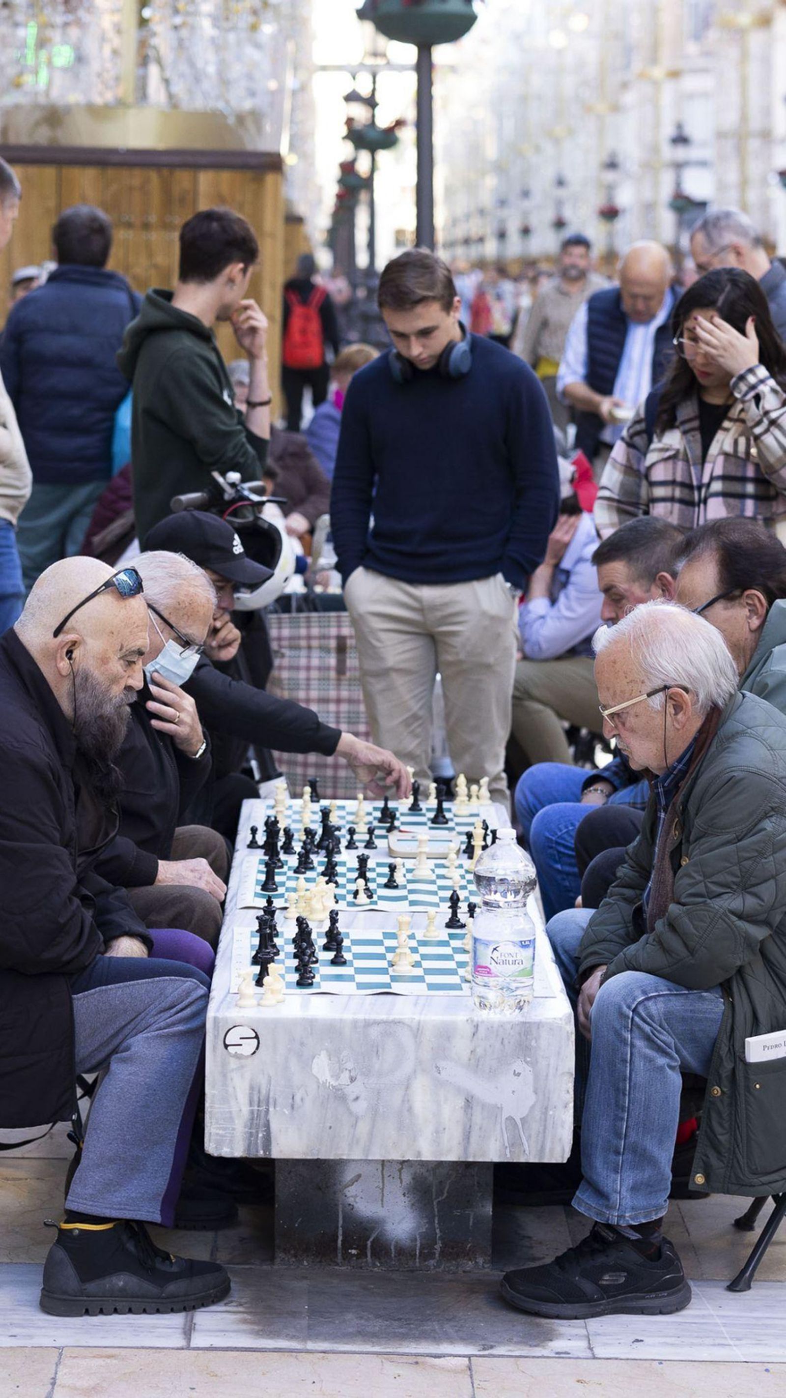 Público congregado en torno a los tableros de ajedrez.