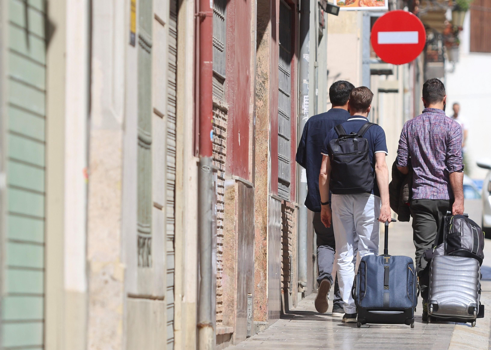 Turistas en Málaga arrastran maletas.