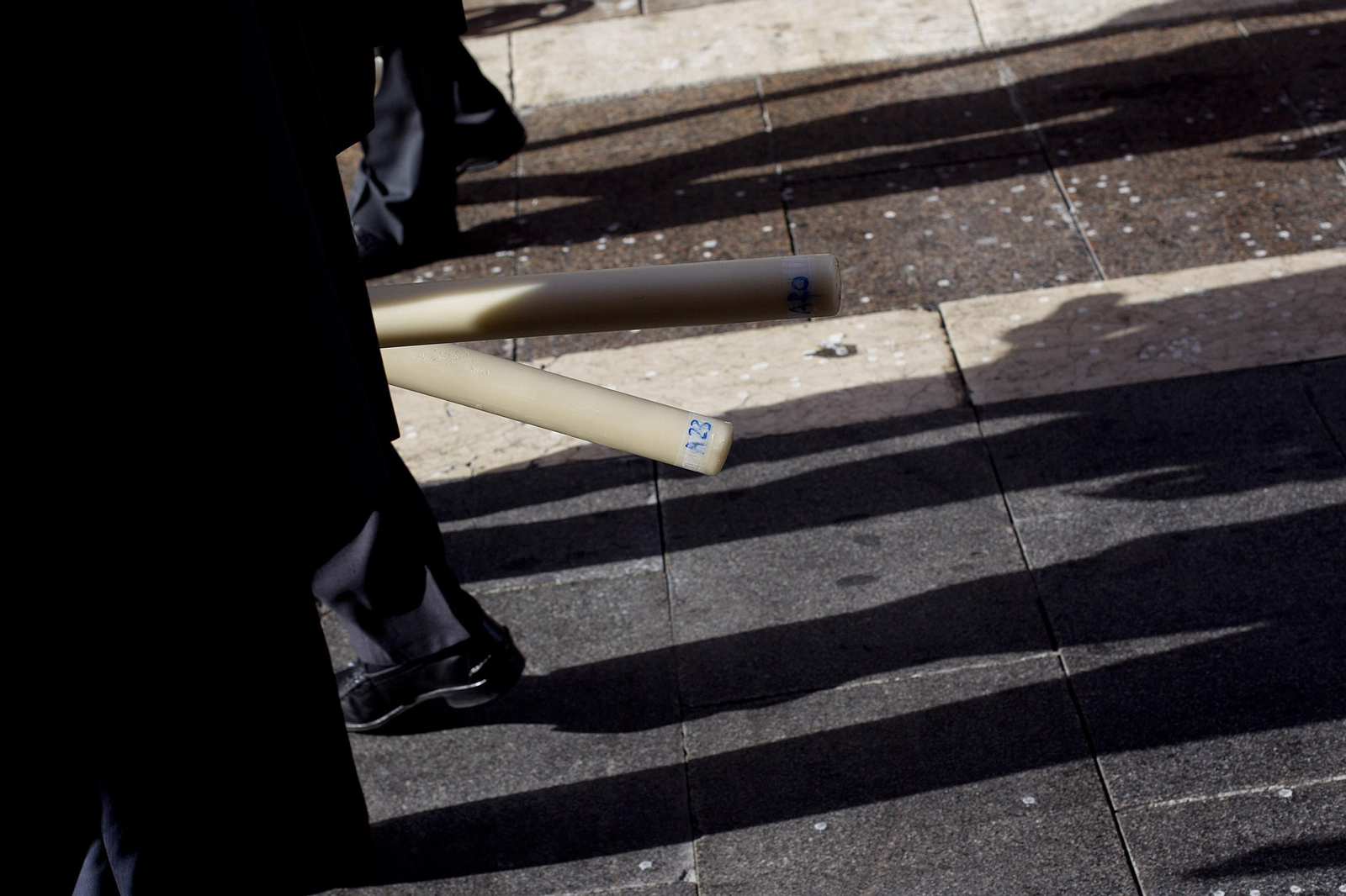 Los participantes de una procesión portando cirios.