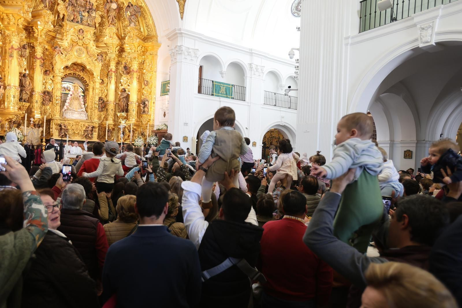 Padres y madres presentan a sus hijos ante la Virgen del Rocío.