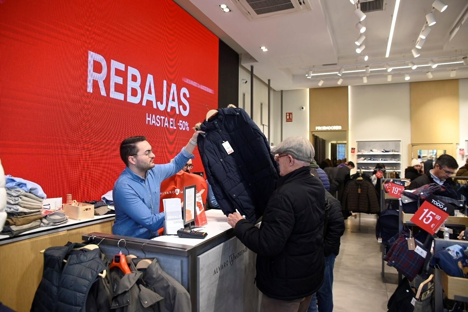 Un dependiente atiende a un cliente en una tienda en periodo de rebajas.