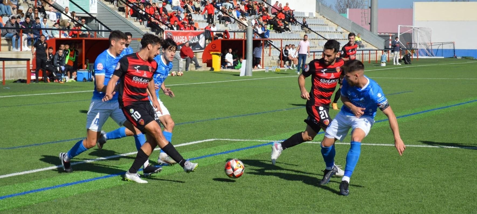 Salva Vegas golpea el balón ante la presión de tres rivales.