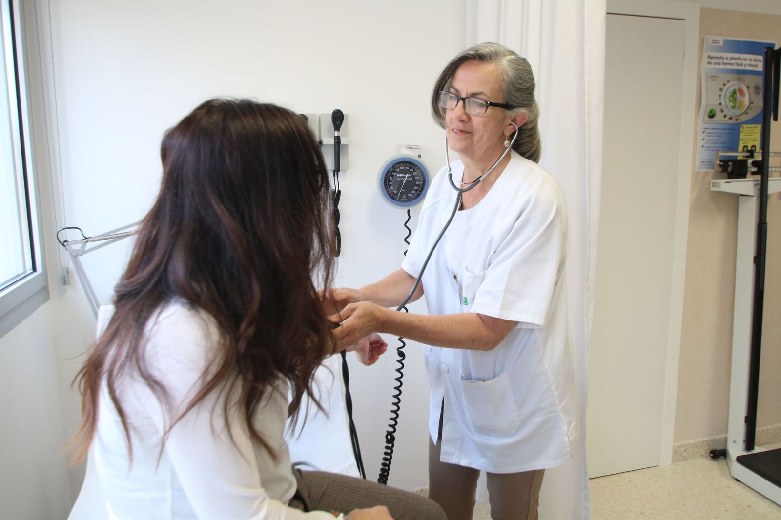 Una enfermera de referencia toma la tensión a una paciente.