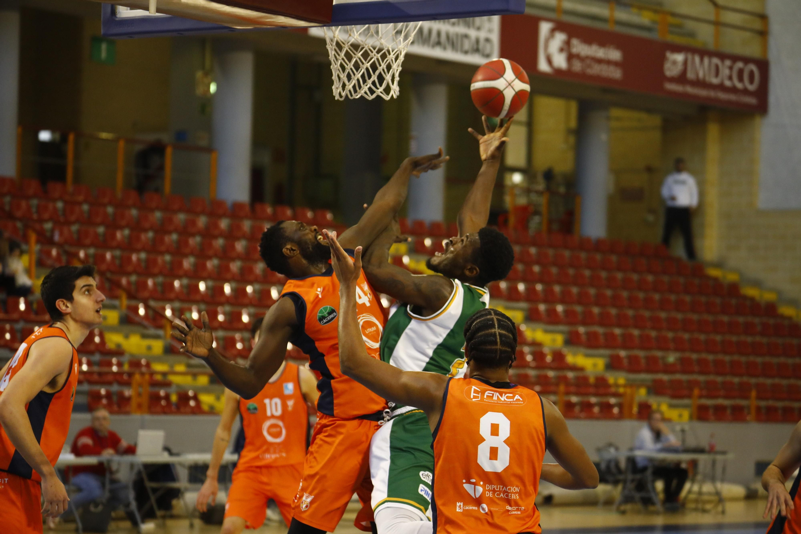 Maxwell Amoafo (Coto Córdoba) lanza ante la oposición de dos jugadores del Sagrado Cáceres.