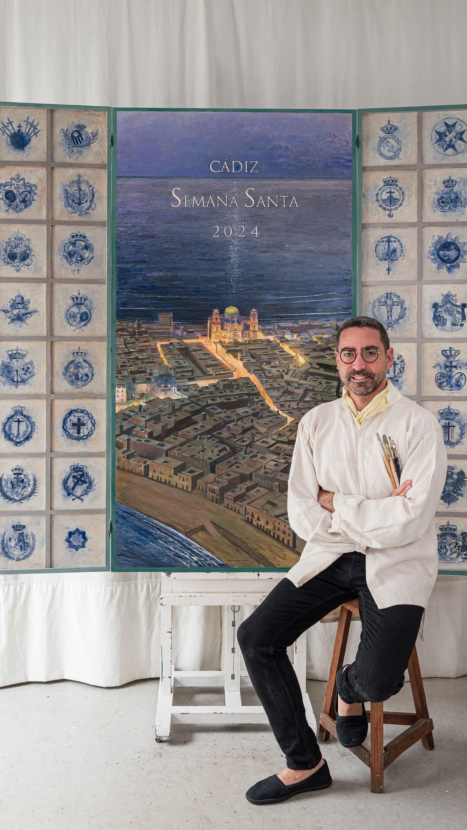 El pintor del cartel de la Semana Santa de Cádiz, Chema Rodríguez, junto a la obra.