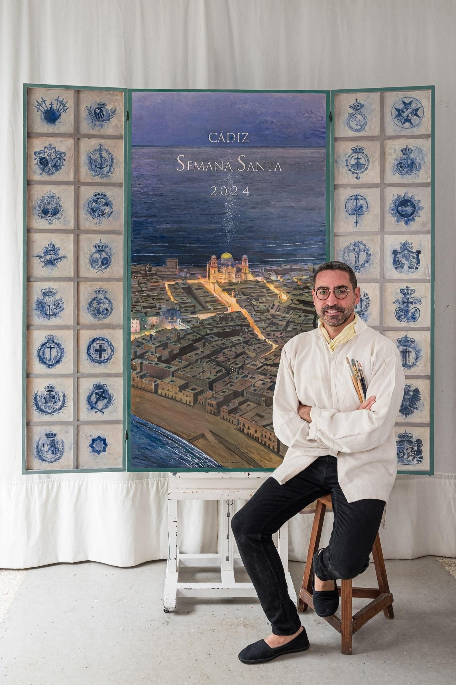 El pintor del cartel de la Semana Santa de Cádiz, Chema Rodríguez, junto a la obra.